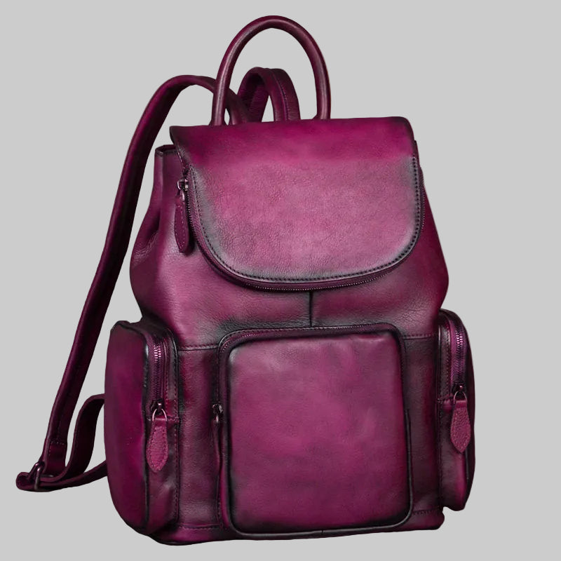 Purple leather backpack on a wooden surface with a neutral background