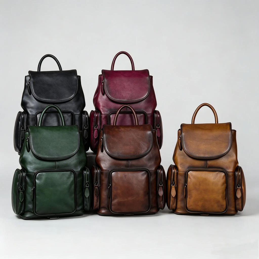 Five leather backpacks in black, burgundy, green, brown, and red on a light gray background.
