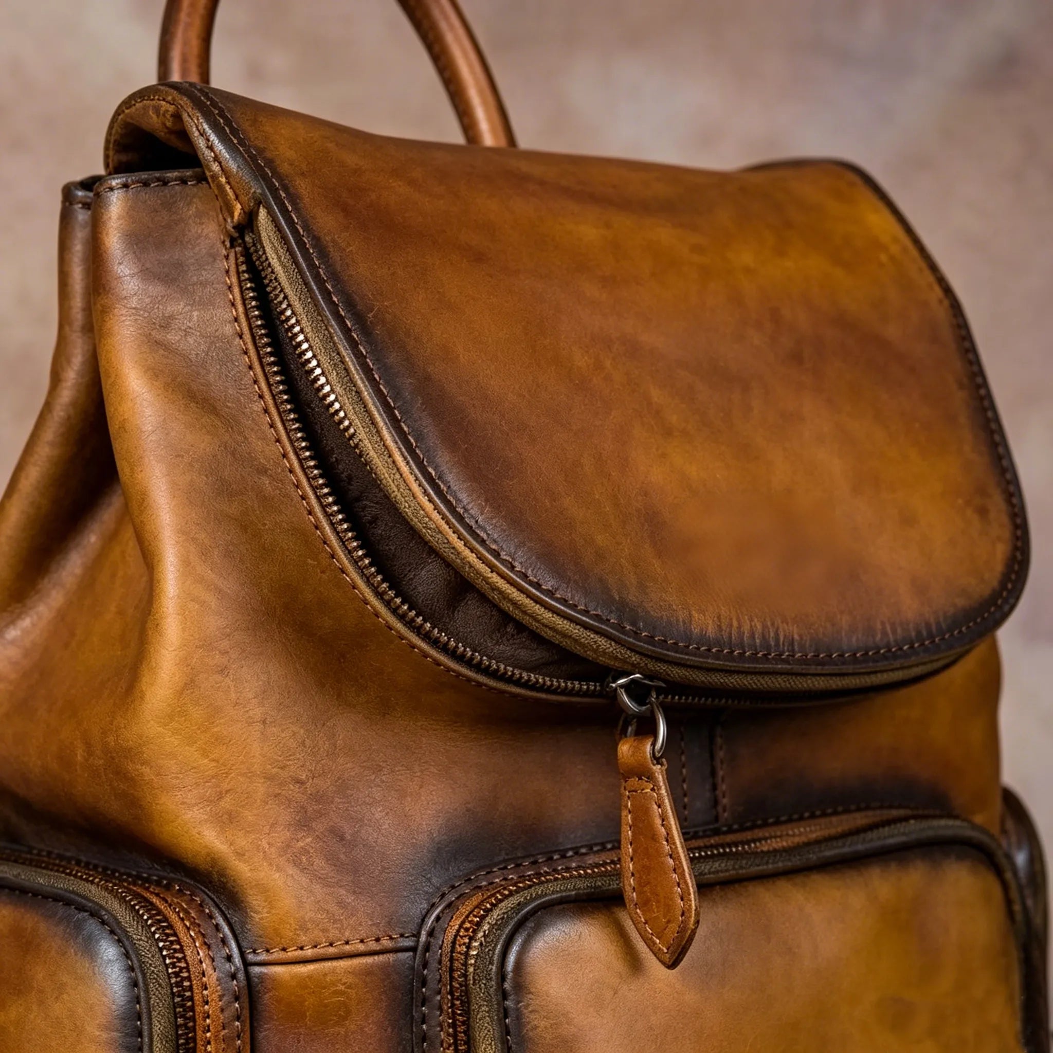 Brown leather backpack with a zipper on a neutral background