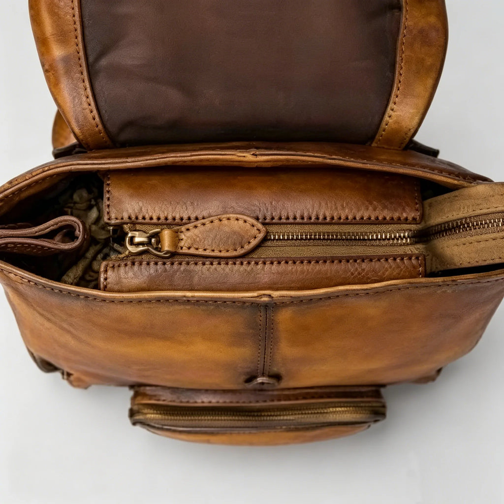 Brown leather bag with multiple zippers on a white background
