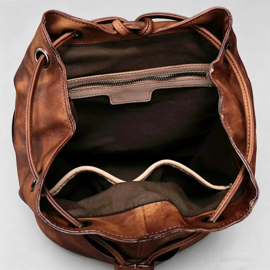 Brown leather bag with drawstring top on a light gray background