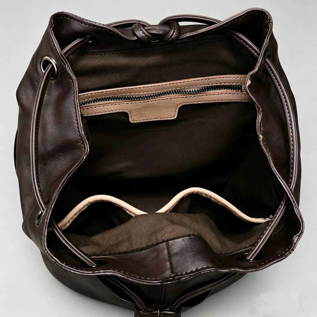 Brown leather bag with a drawstring on a light gray background