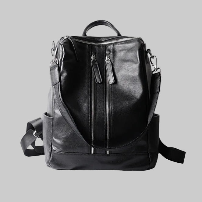 Black full grain leather backpack for women with a double zipper closure and adjustable shoulder strap, displayed against a white background.