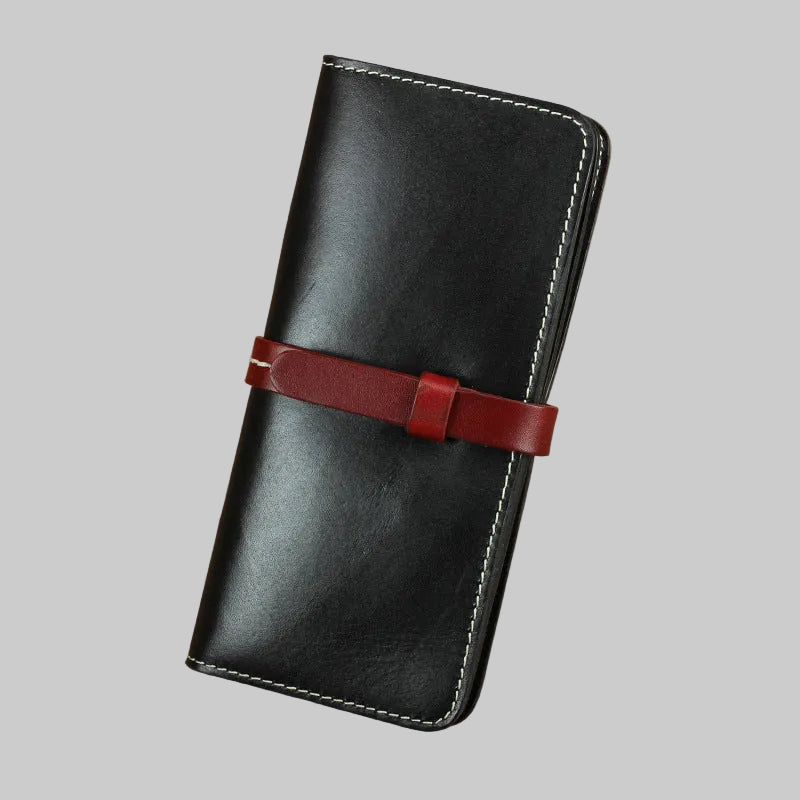 Black leather wallet with a red strap on a brown background