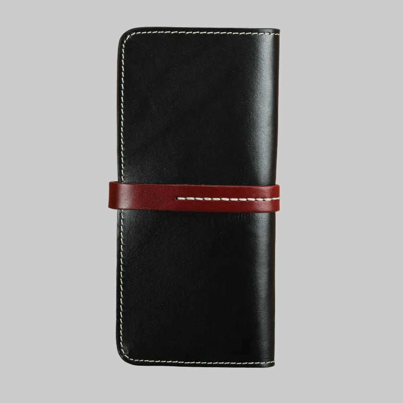 Black leather wallet with a red strap on a brown background