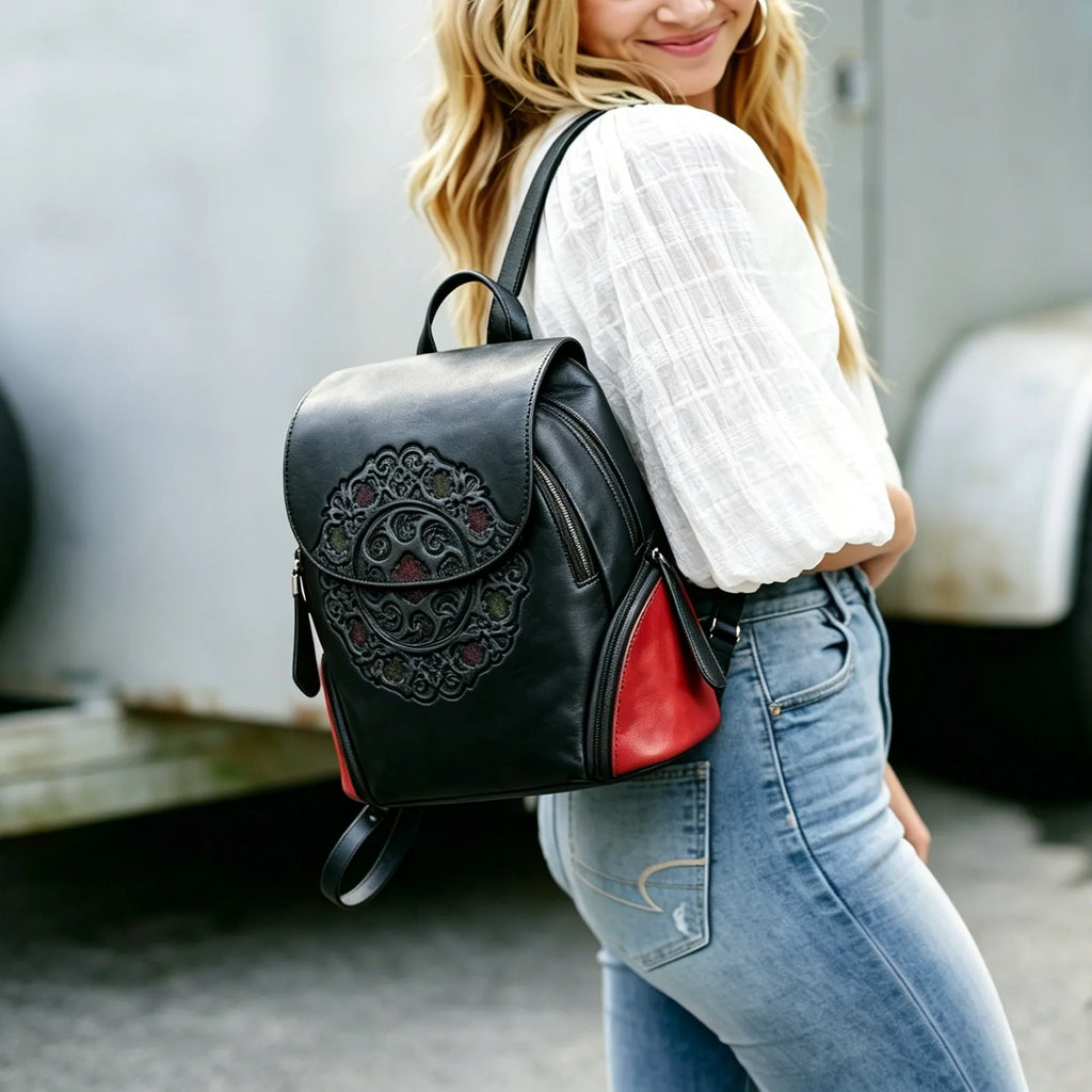 Person wearing a black backpack with red accents, standing indoors.