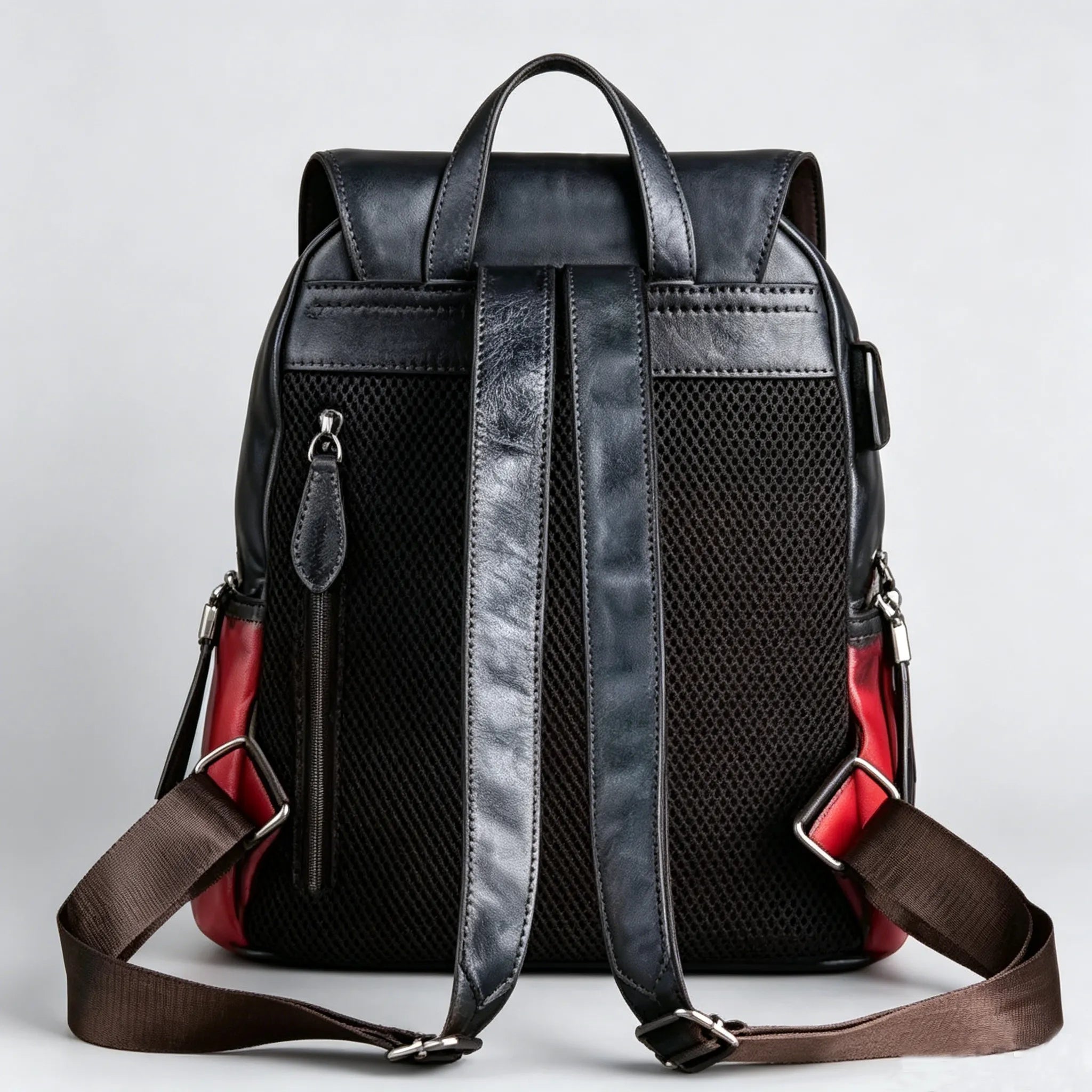 Black leather backpack with red interior on a light gray background