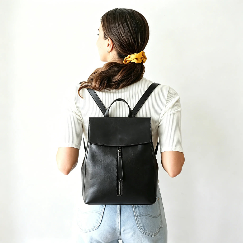 Person wearing a black backpack on a plain background
