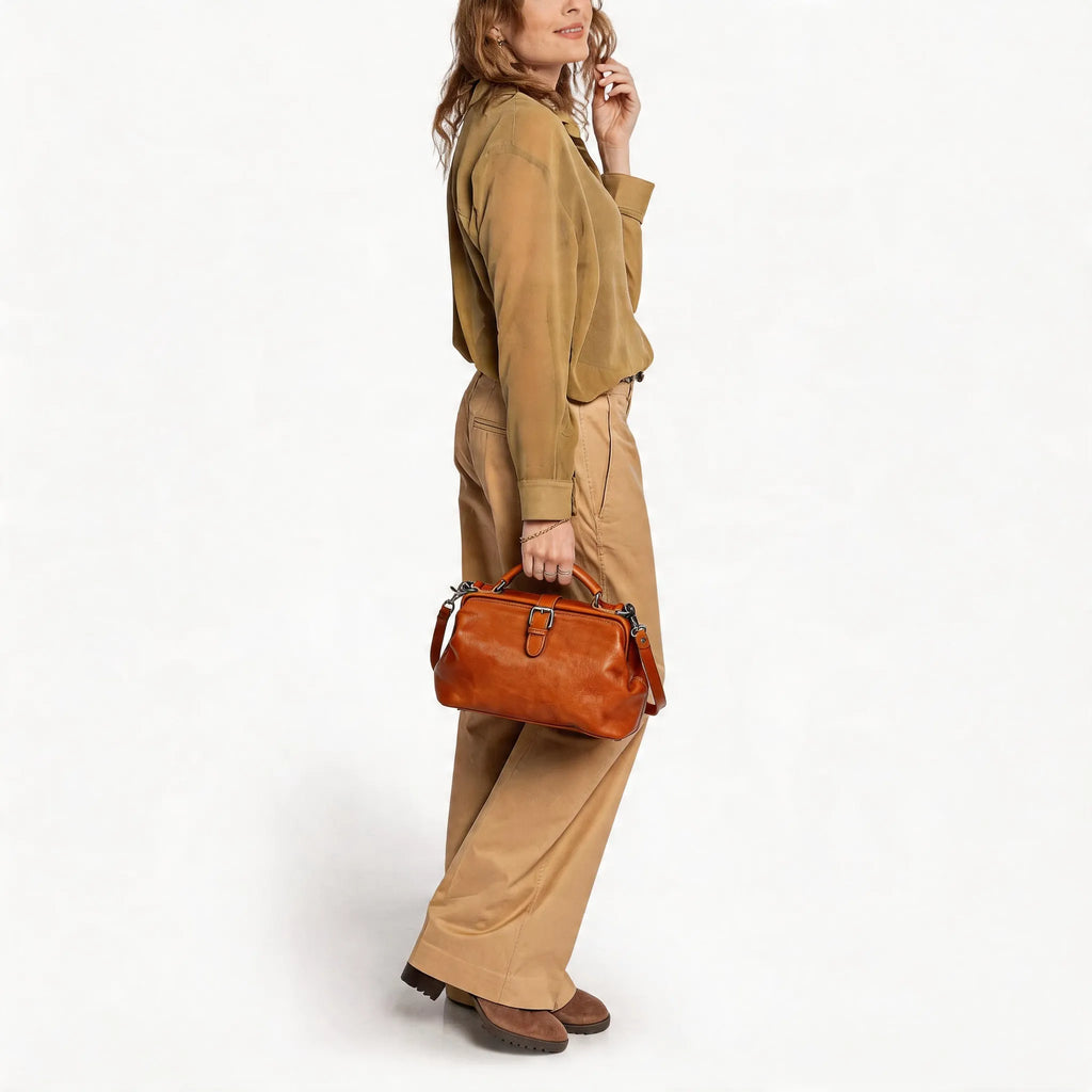 Woman holding a brown leather bag against a white background
