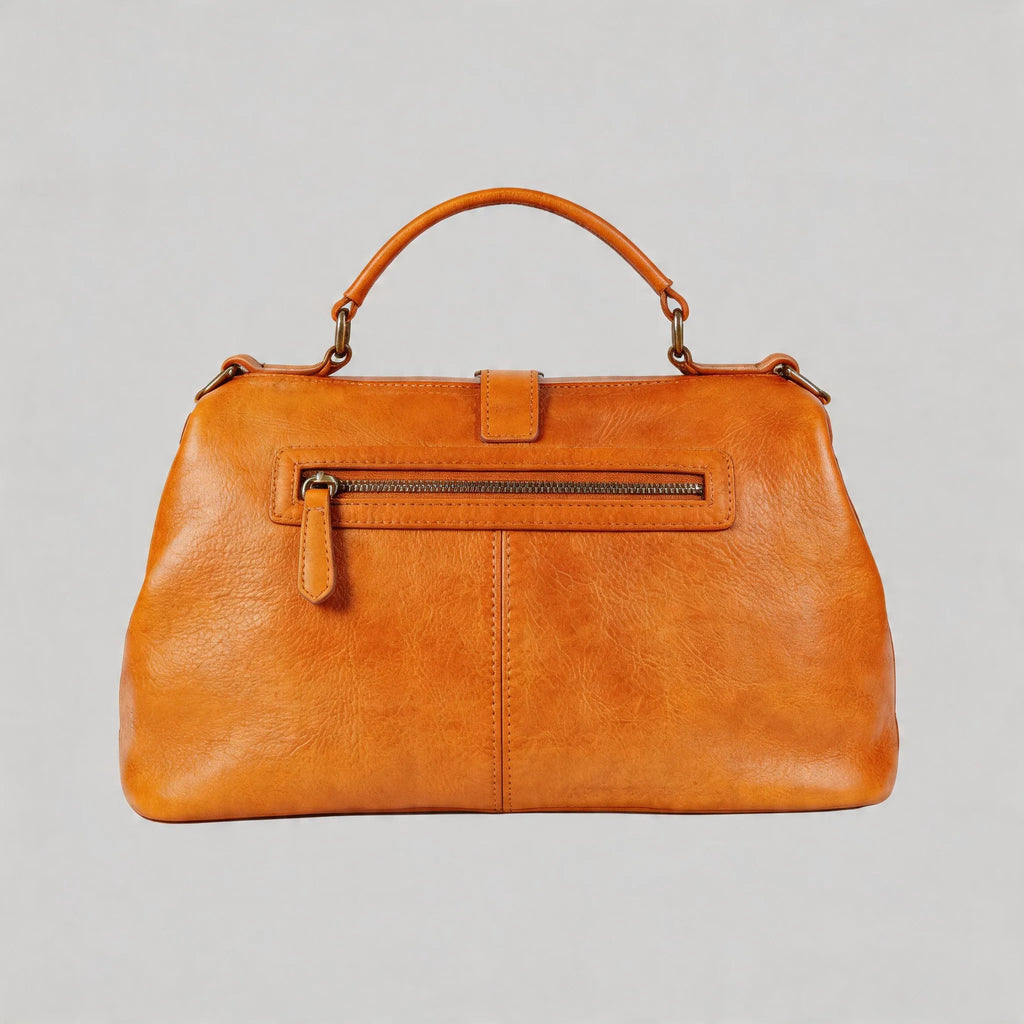 Brown leather handbag with a gold zipper on a light gray background