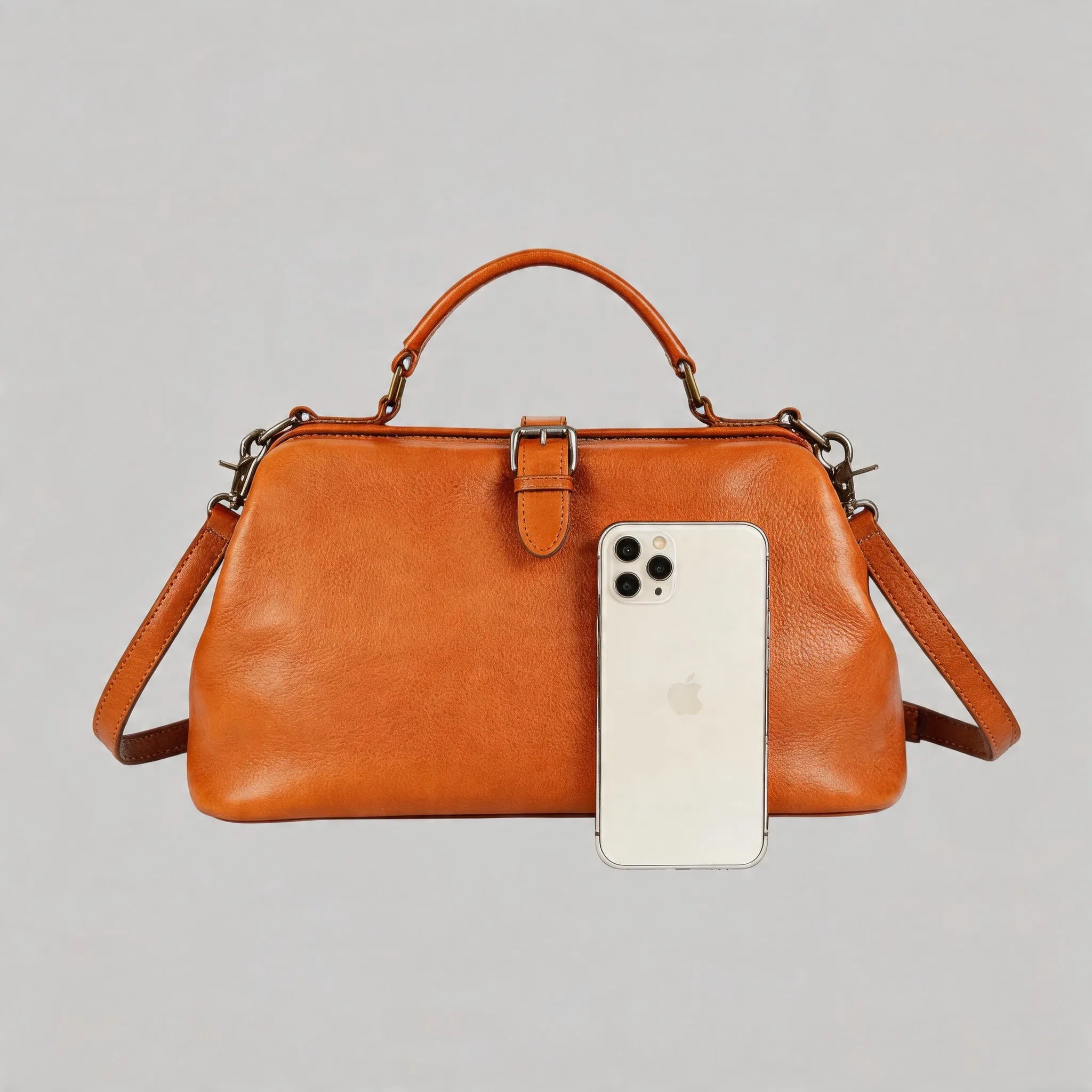 Brown leather handbag with a smartphone on a gray background
