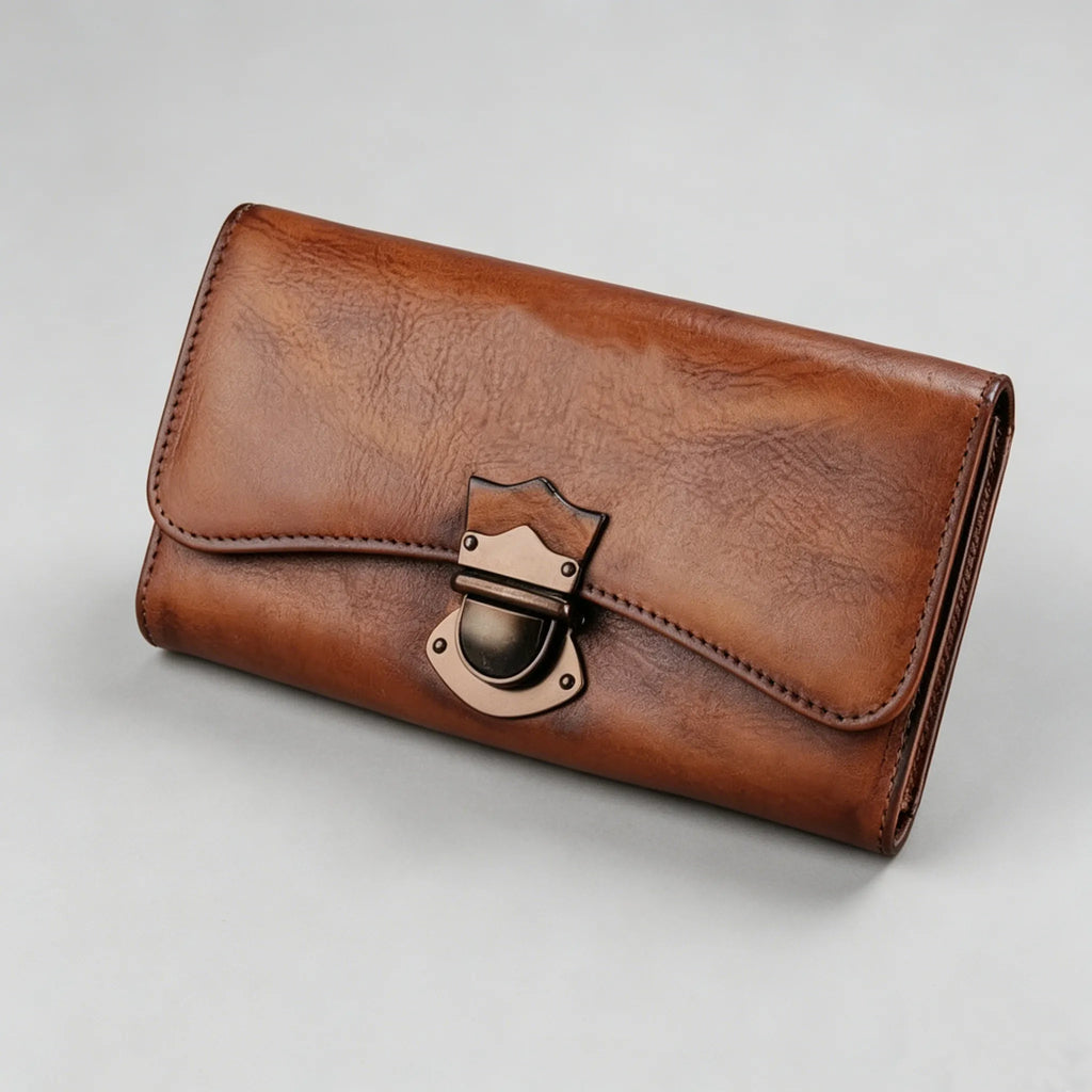 Brown leather wallet with a gold clasp on a light gray background