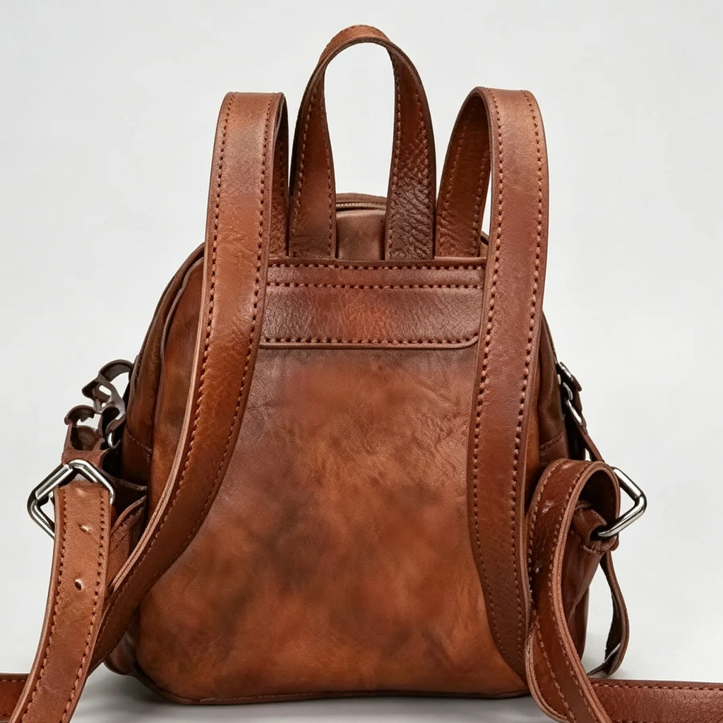 Brown leather backpack on a light gray background