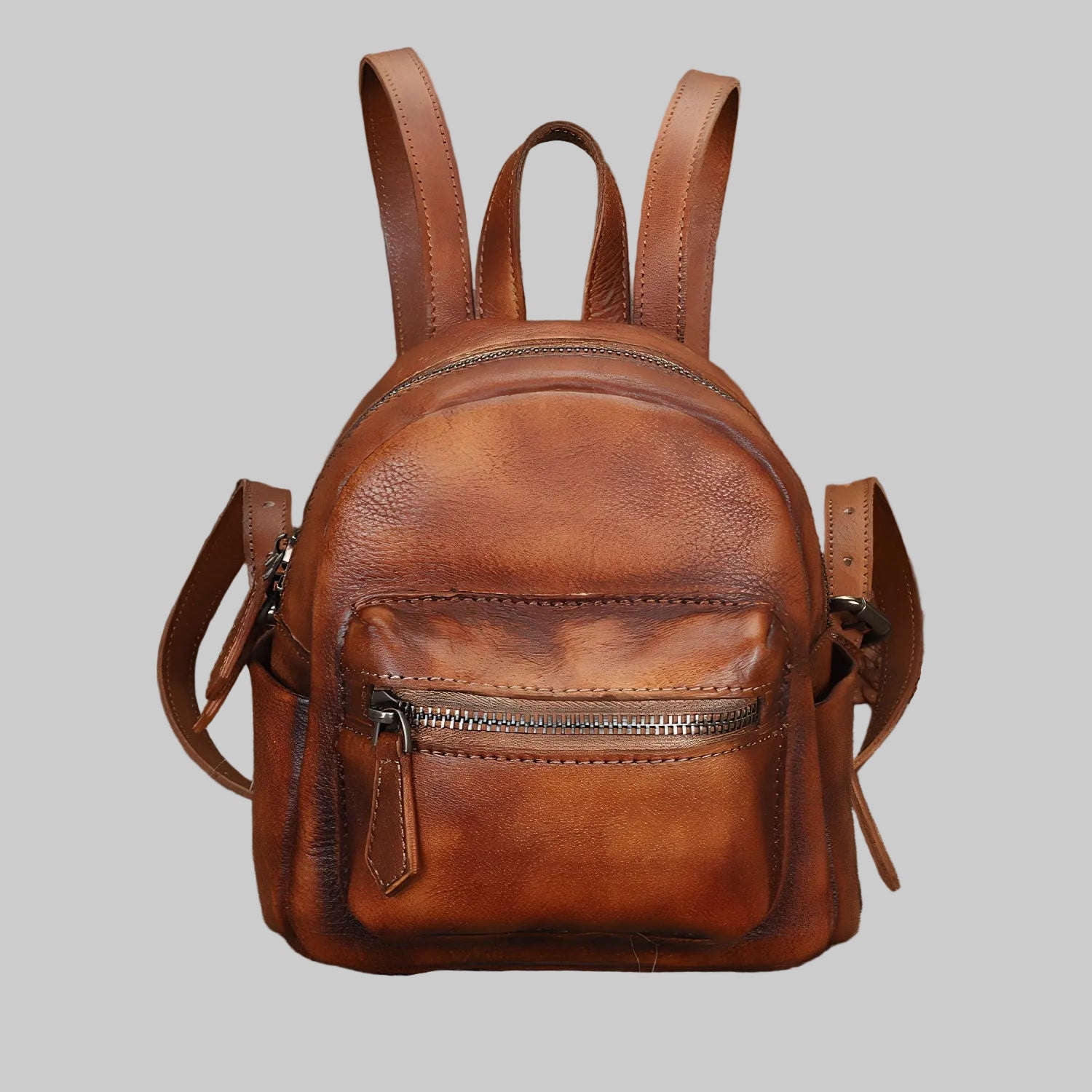 Brown leather backpack on a gray background