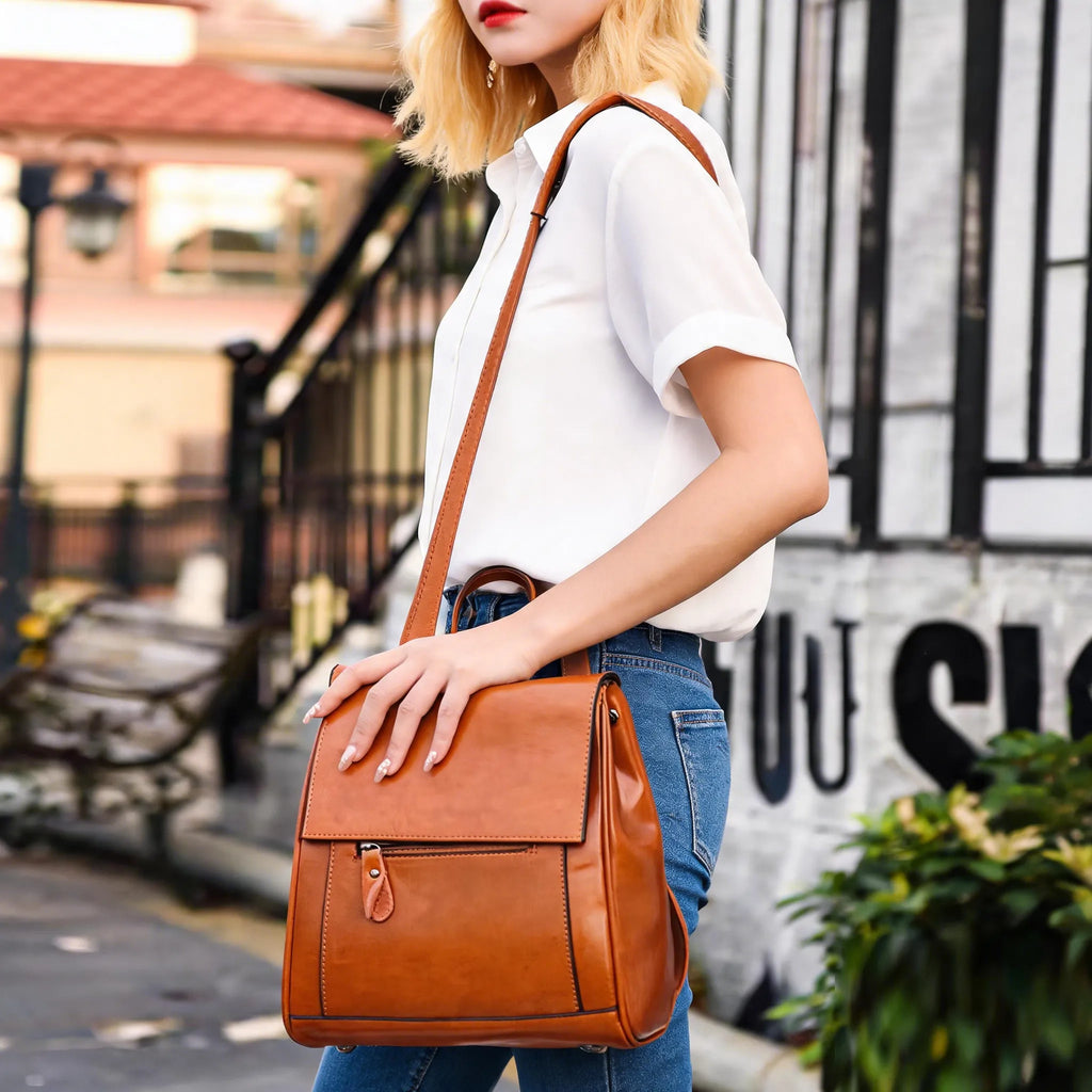Woman holding a brown leather backpack in an urban setting