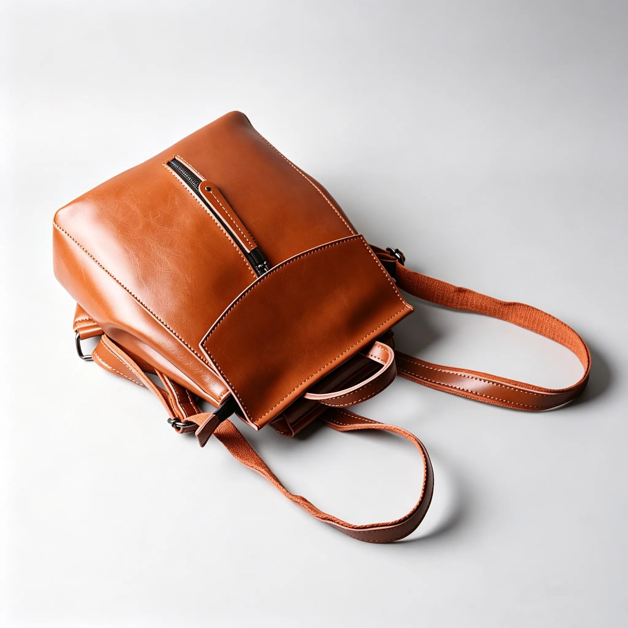 Brown leather backpack on a light gray background