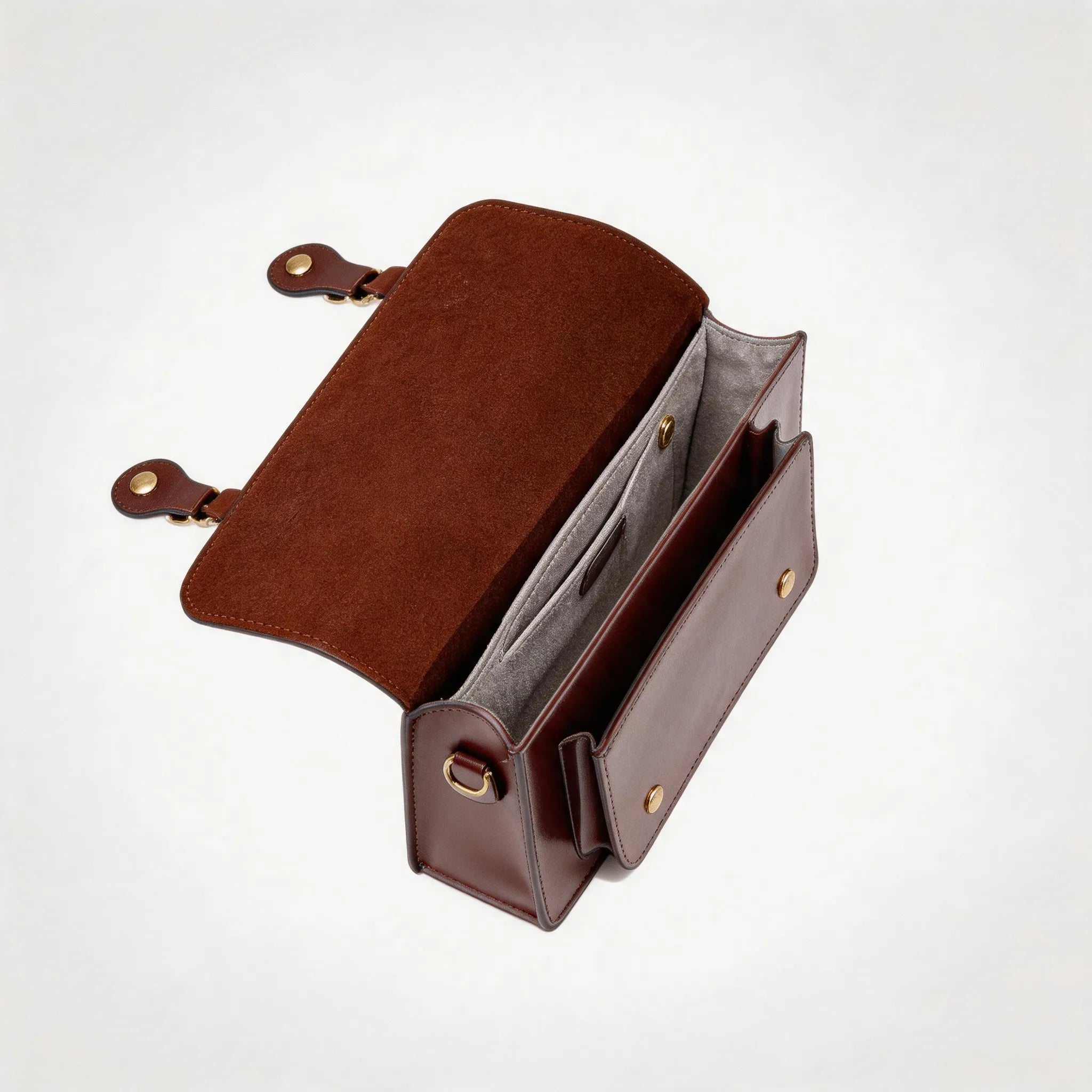 Brown leather bag with gold hardware on a white background