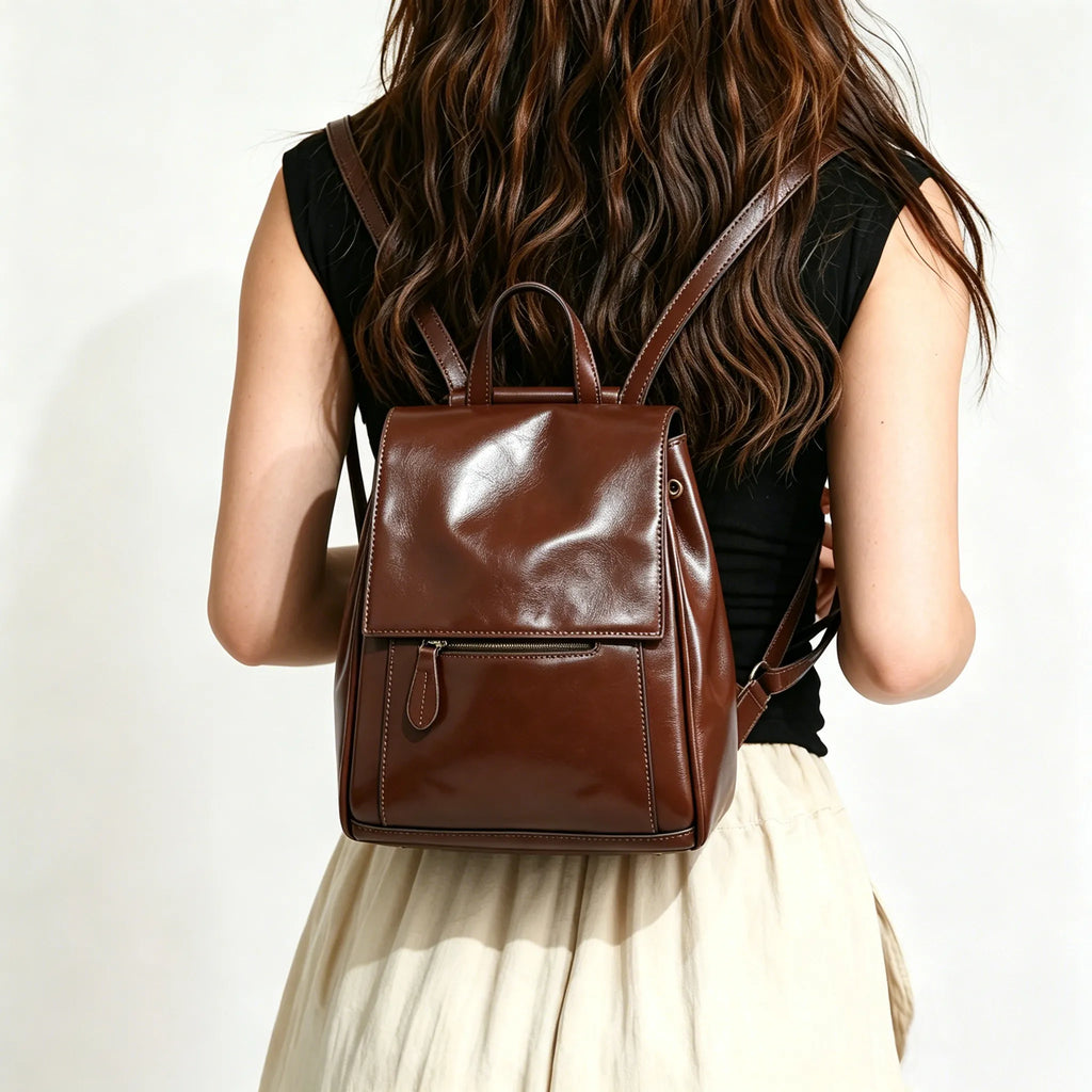Person wearing a brown leather backpack on a plain background