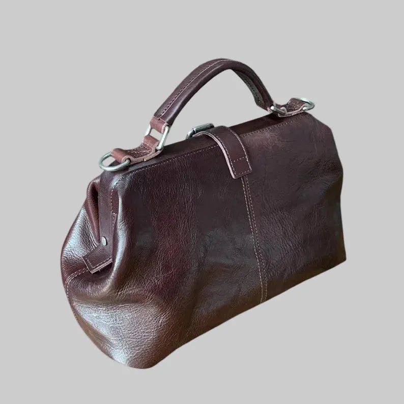 Brown leather handbag on a light gray background