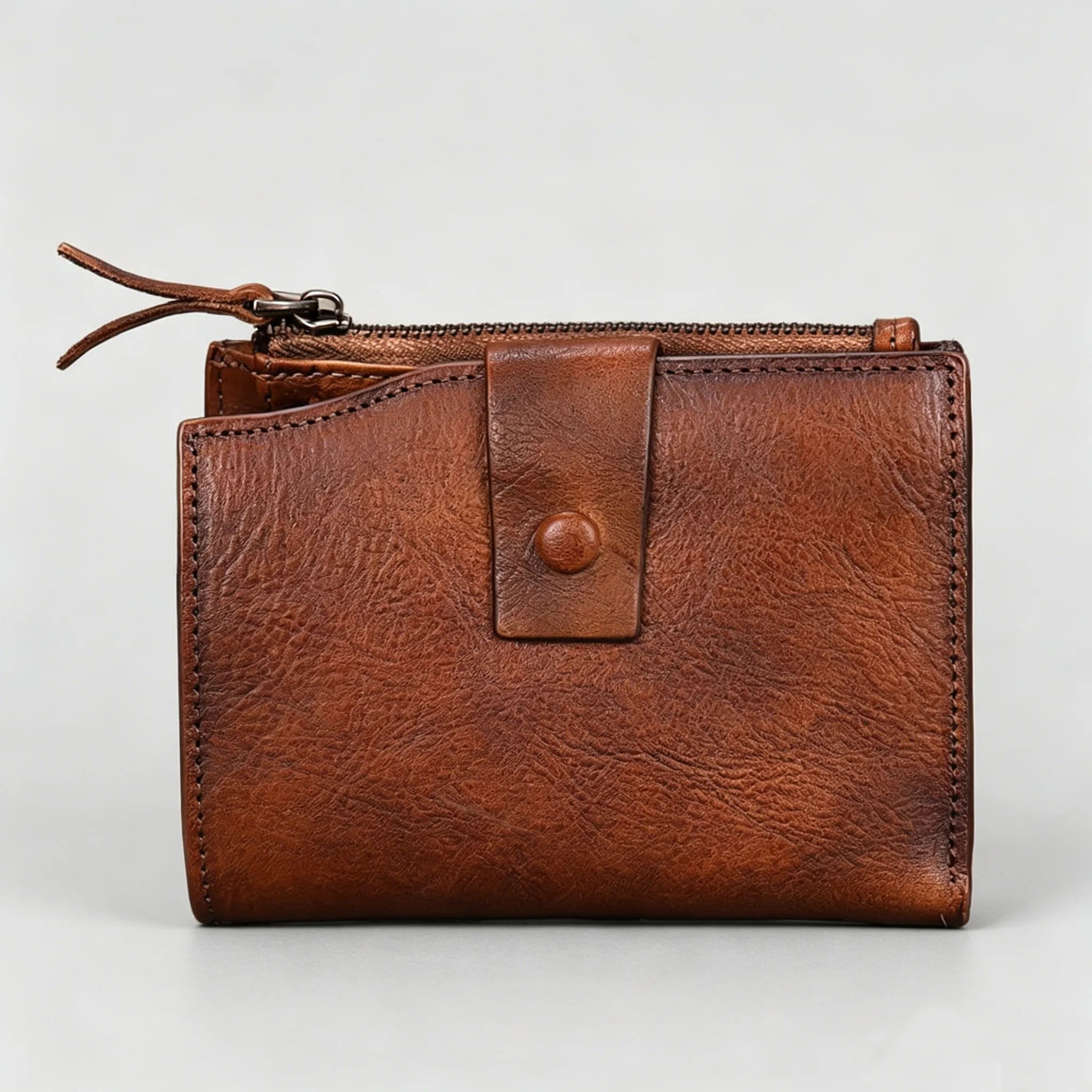 Brown leather wallet with a zipper on a light gray background