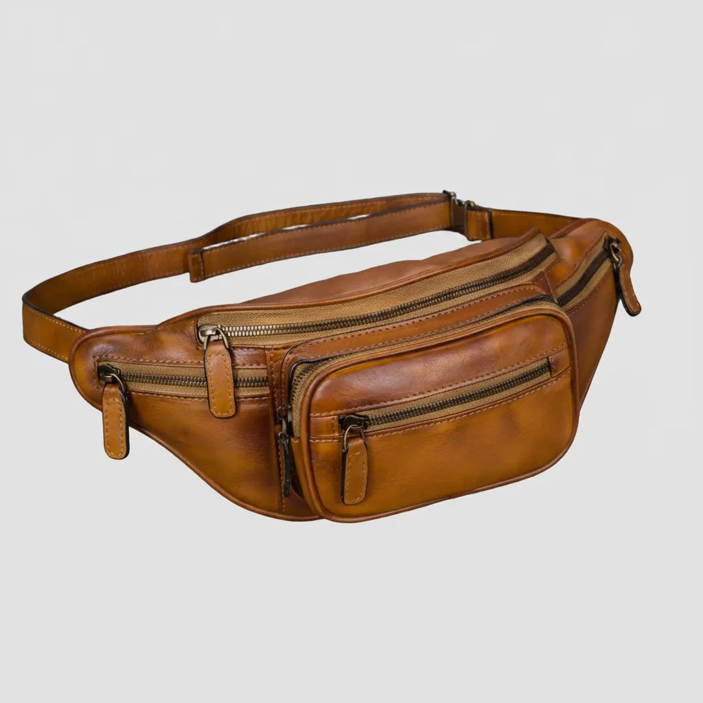 Brown leather waist bag with multiple zippers on a light gray background