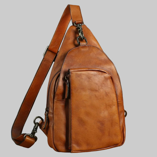Brown leather sling bag on a gray background