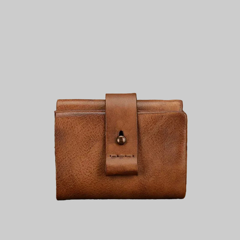 Brown leather wallet on a textured surface with natural background