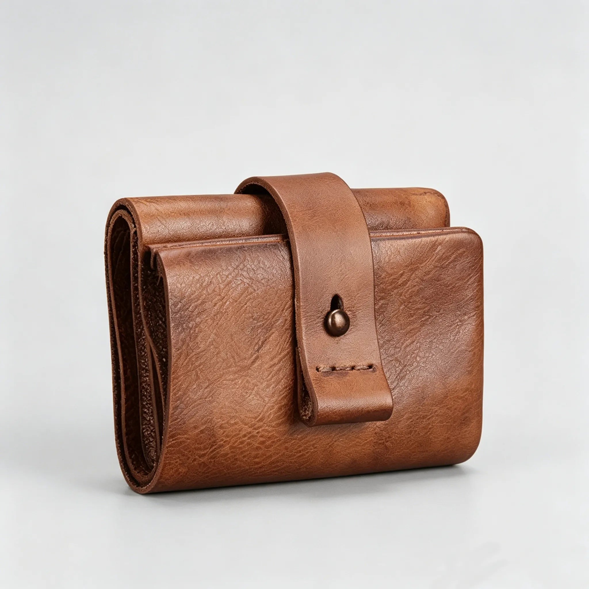 Brown leather wallet with strap on a light gray background