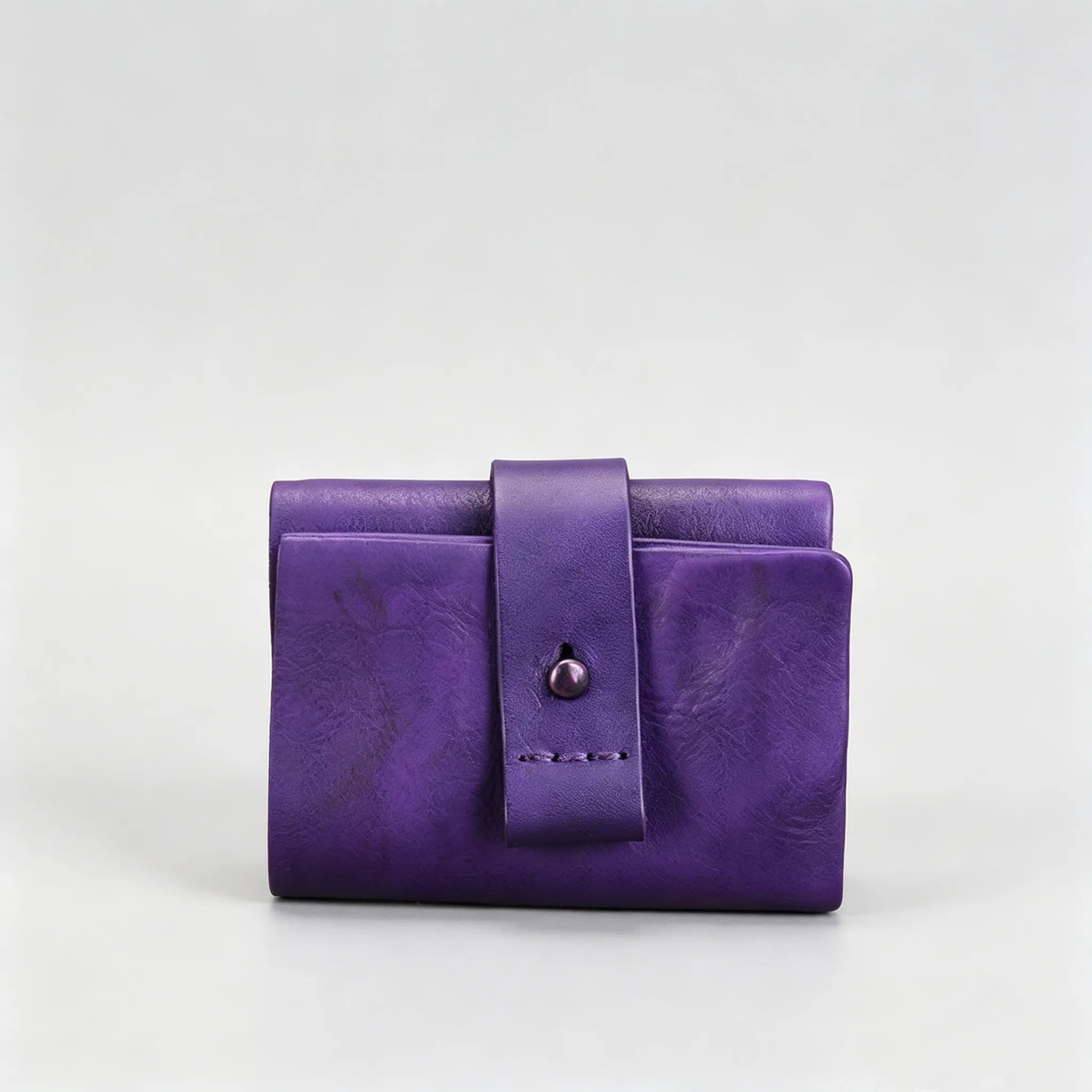 Purple leather wallet with a strap on a light gray background