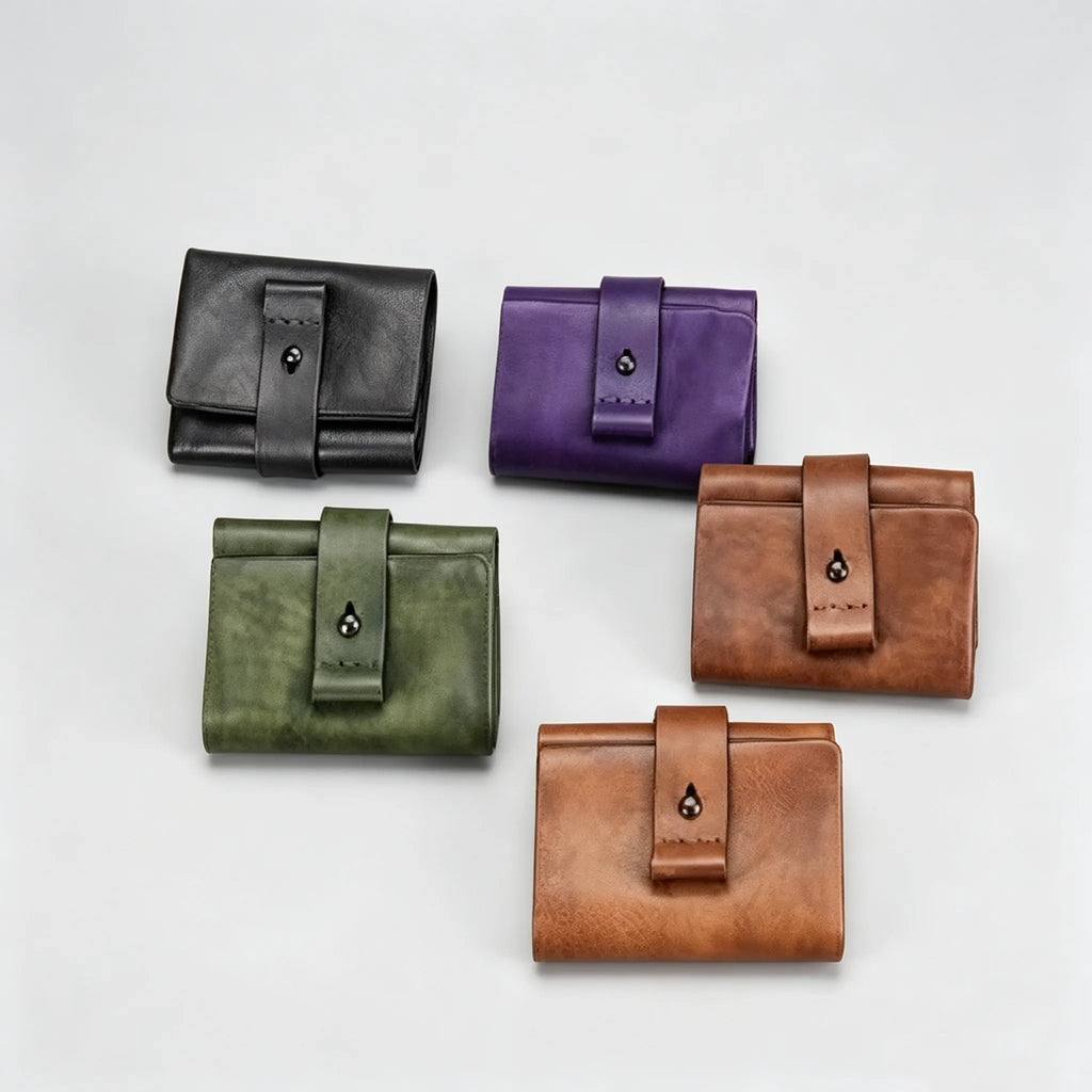 Five leather wallets in black, purple, green, brown, and another brown color on a light gray background.