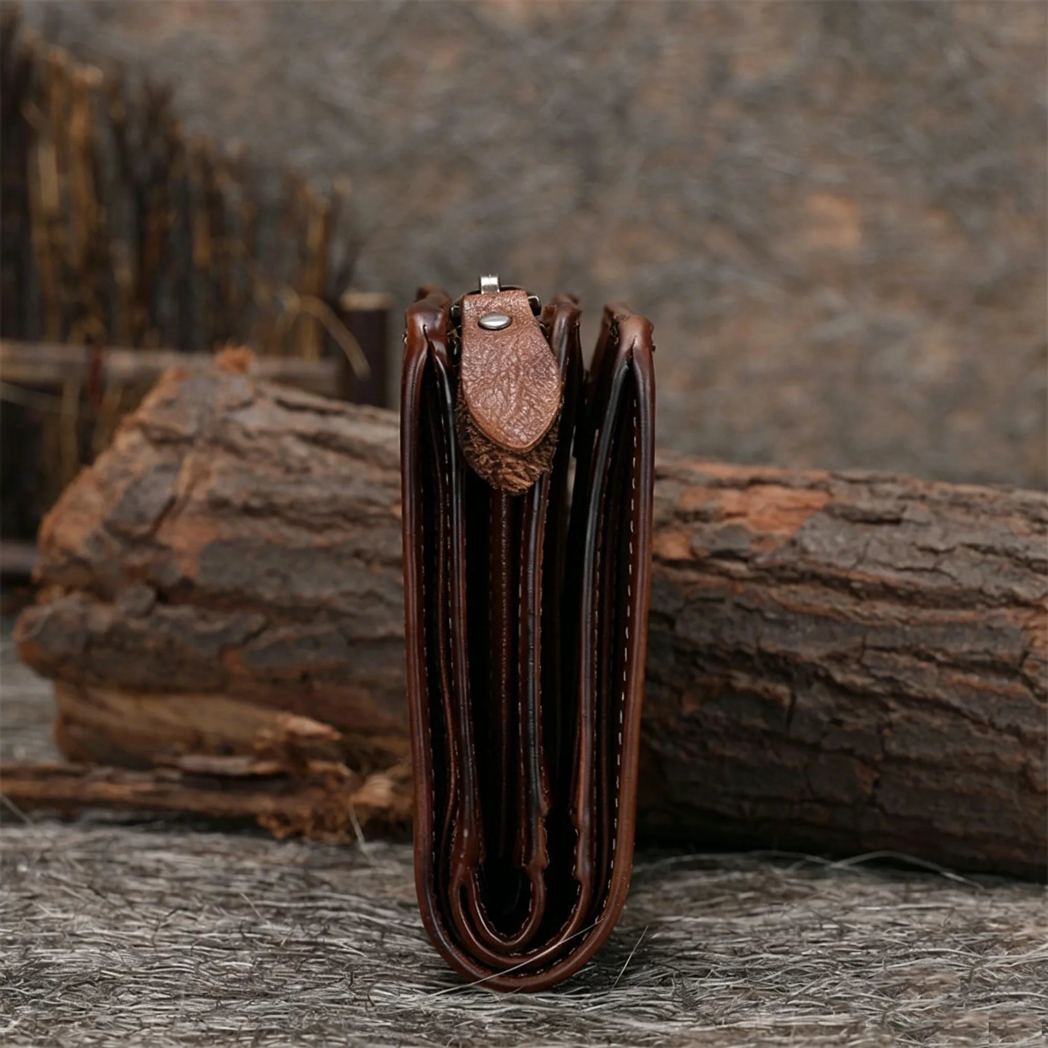 Brown leather wallet on a wooden surface with a blurred natural background