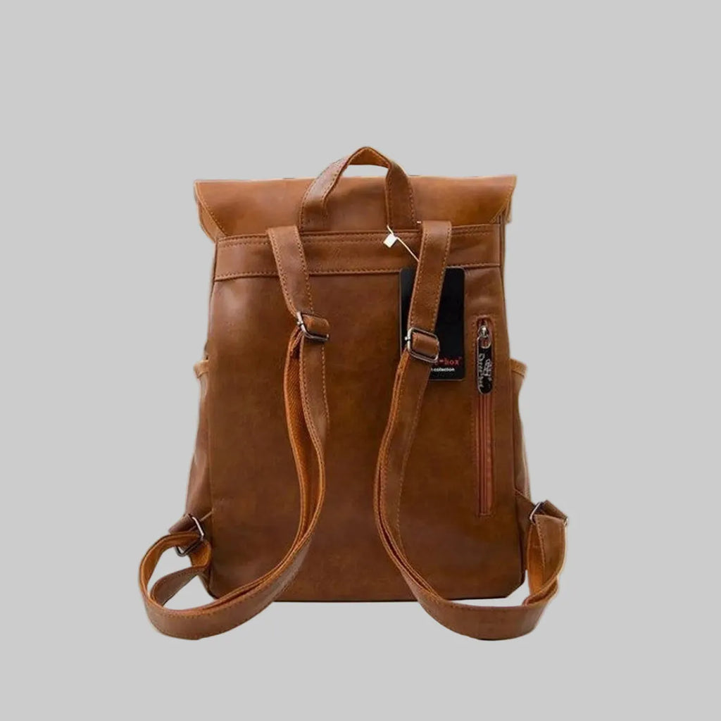 Brown leather backpack on a gray background