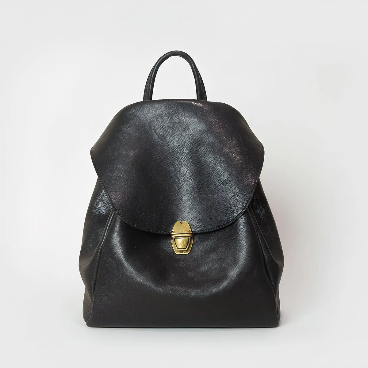Black leather backpack with a gold buckle on a white background