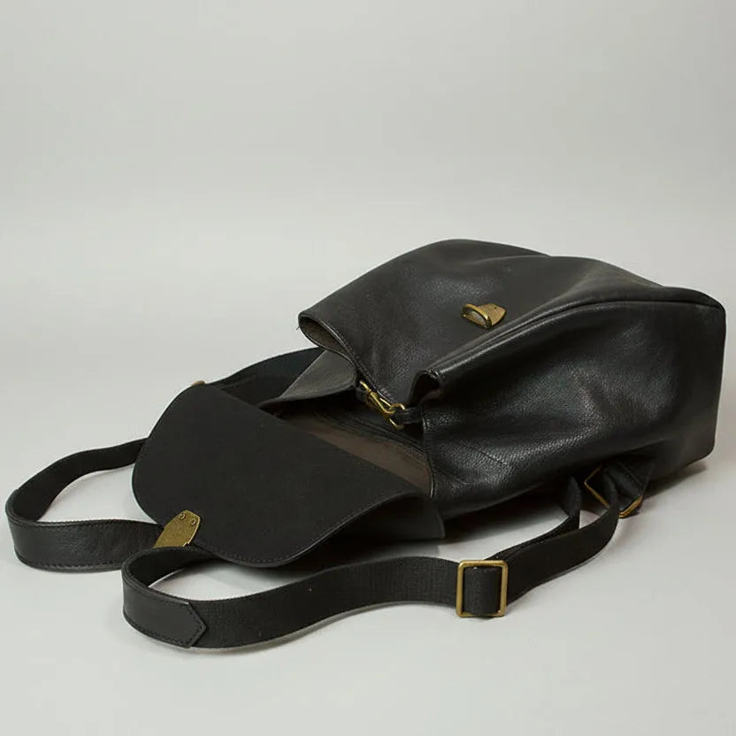 Black leather bag with gold accents on a light gray background