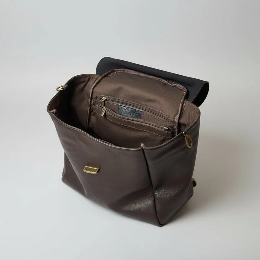Brown leather bag with a black interior on a light gray background