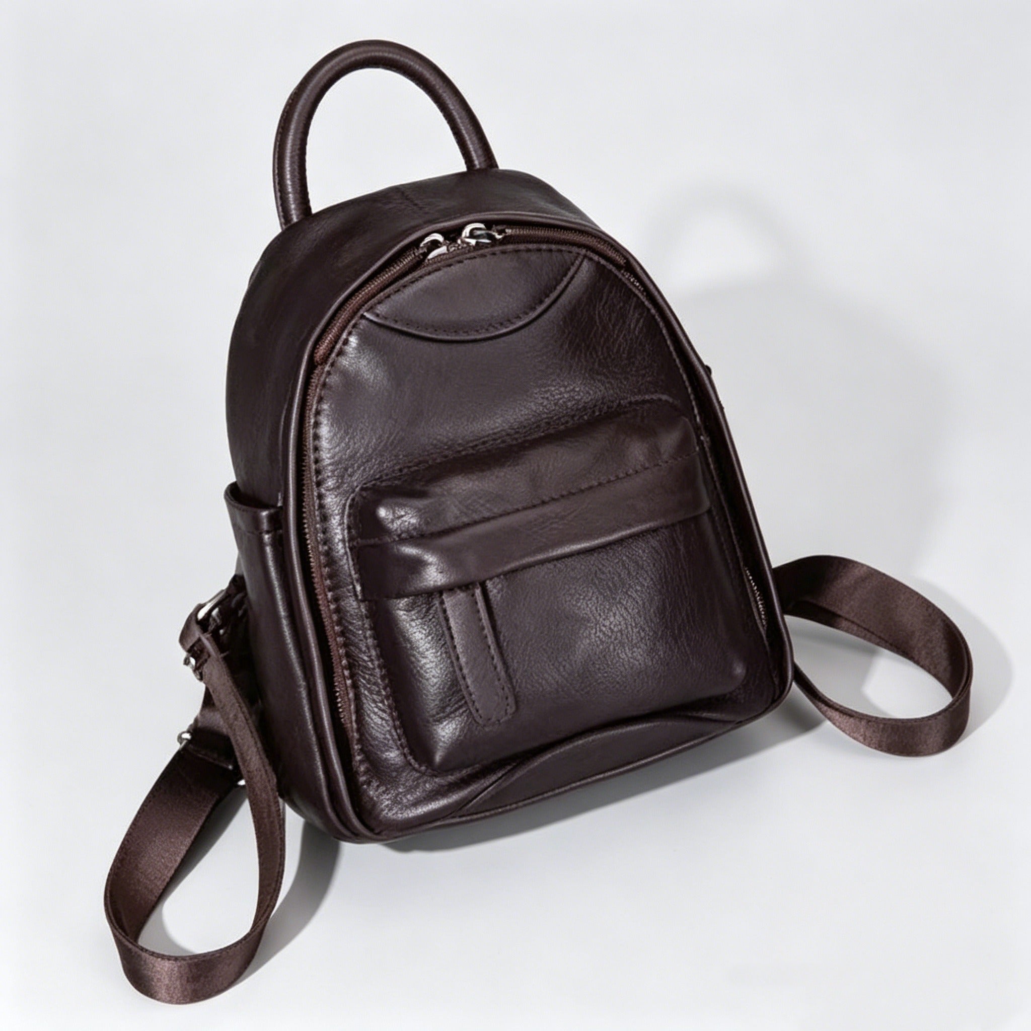 Brown leather backpack on a light gray background