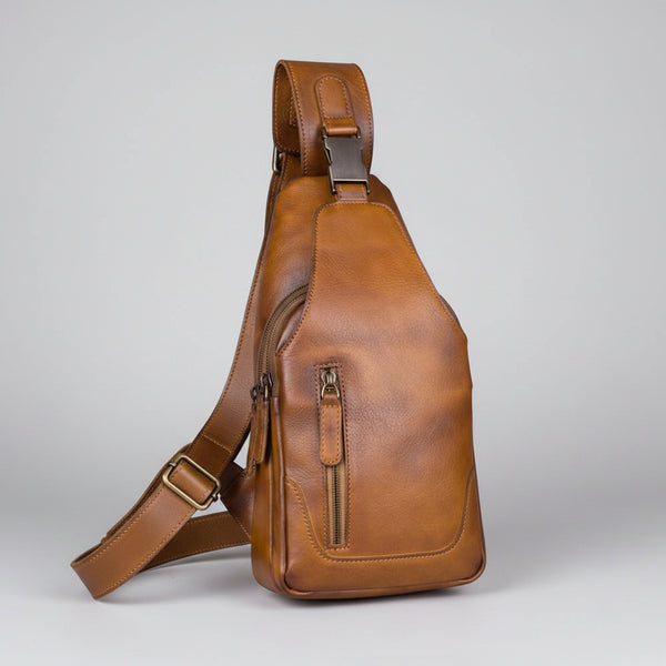 Brown leather sling bag on a light gray background