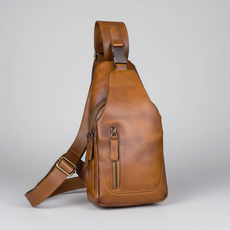 Brown leather sling bag on a light gray background