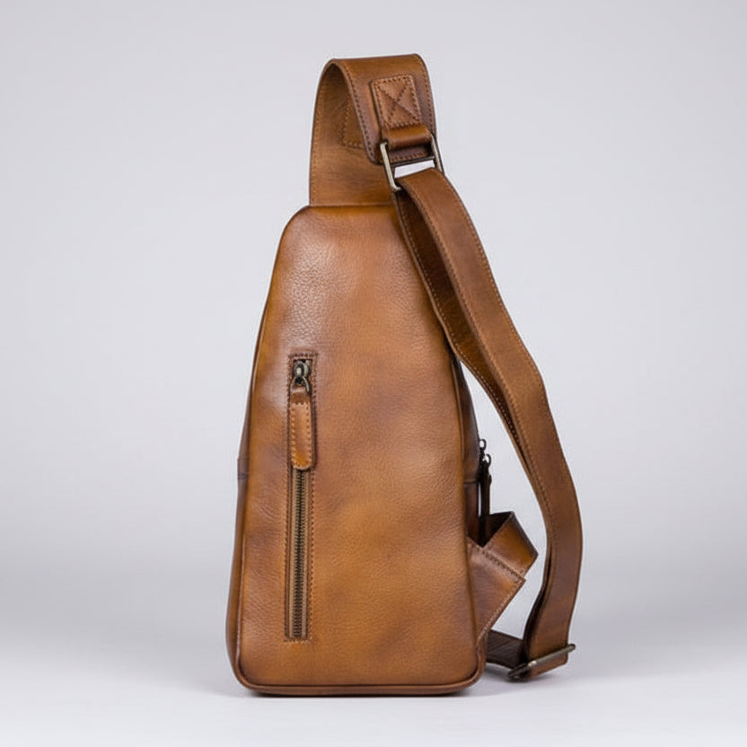 Brown leather sling bag on a light gray background