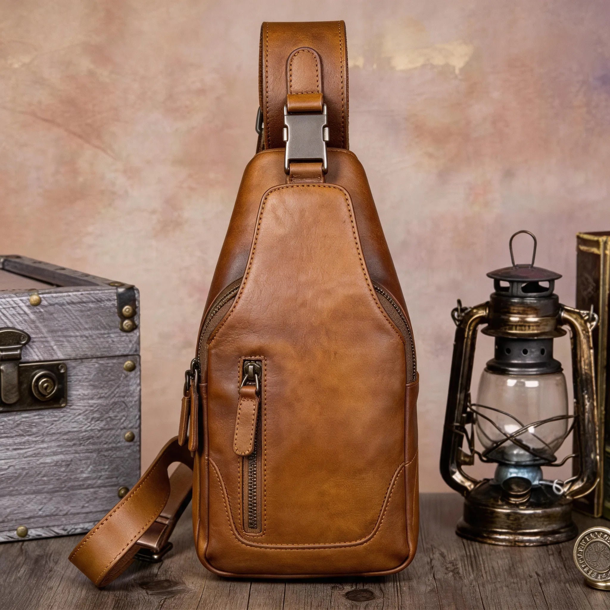 Brown leather sling bag on a wooden surface with a rustic background