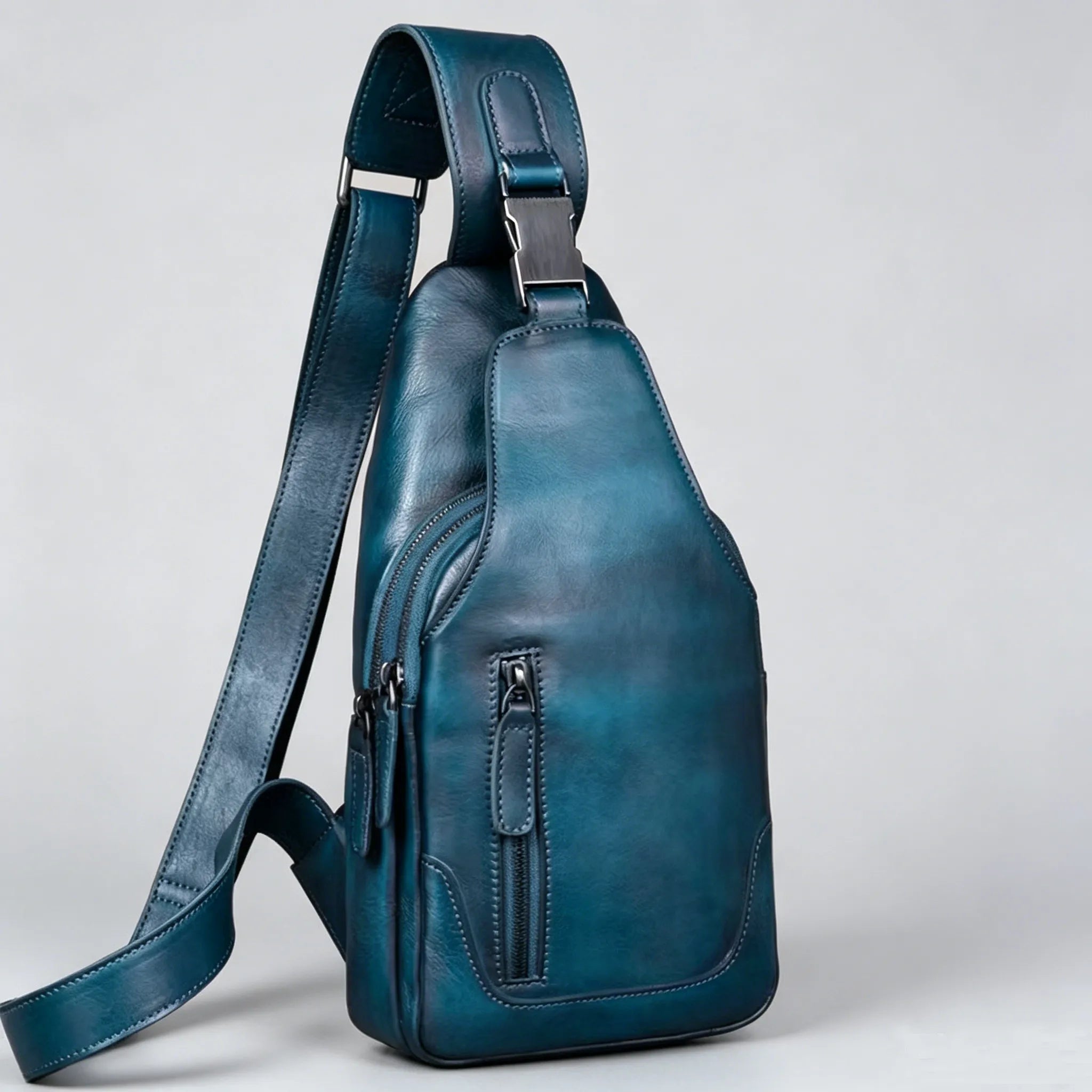Blue leather sling bag on a light gray background