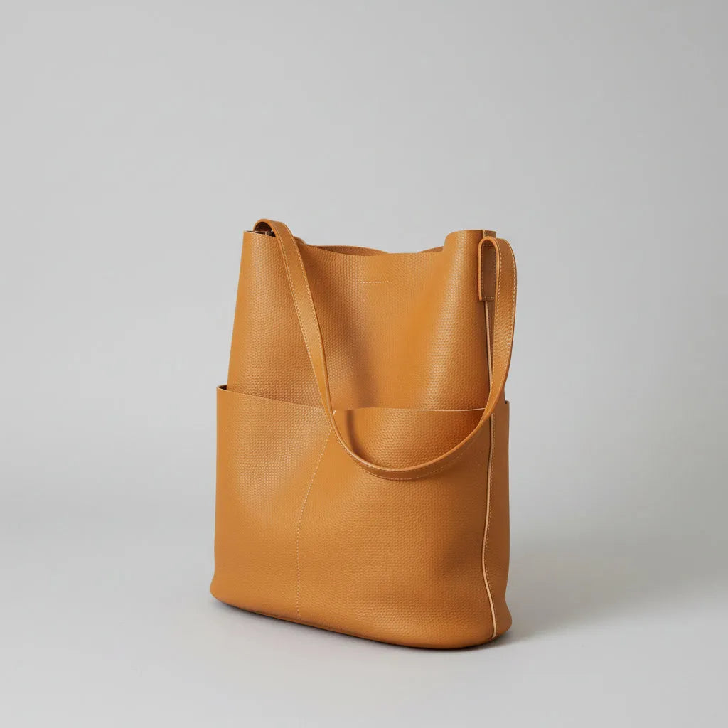 Brown leather tote bag on a light gray background