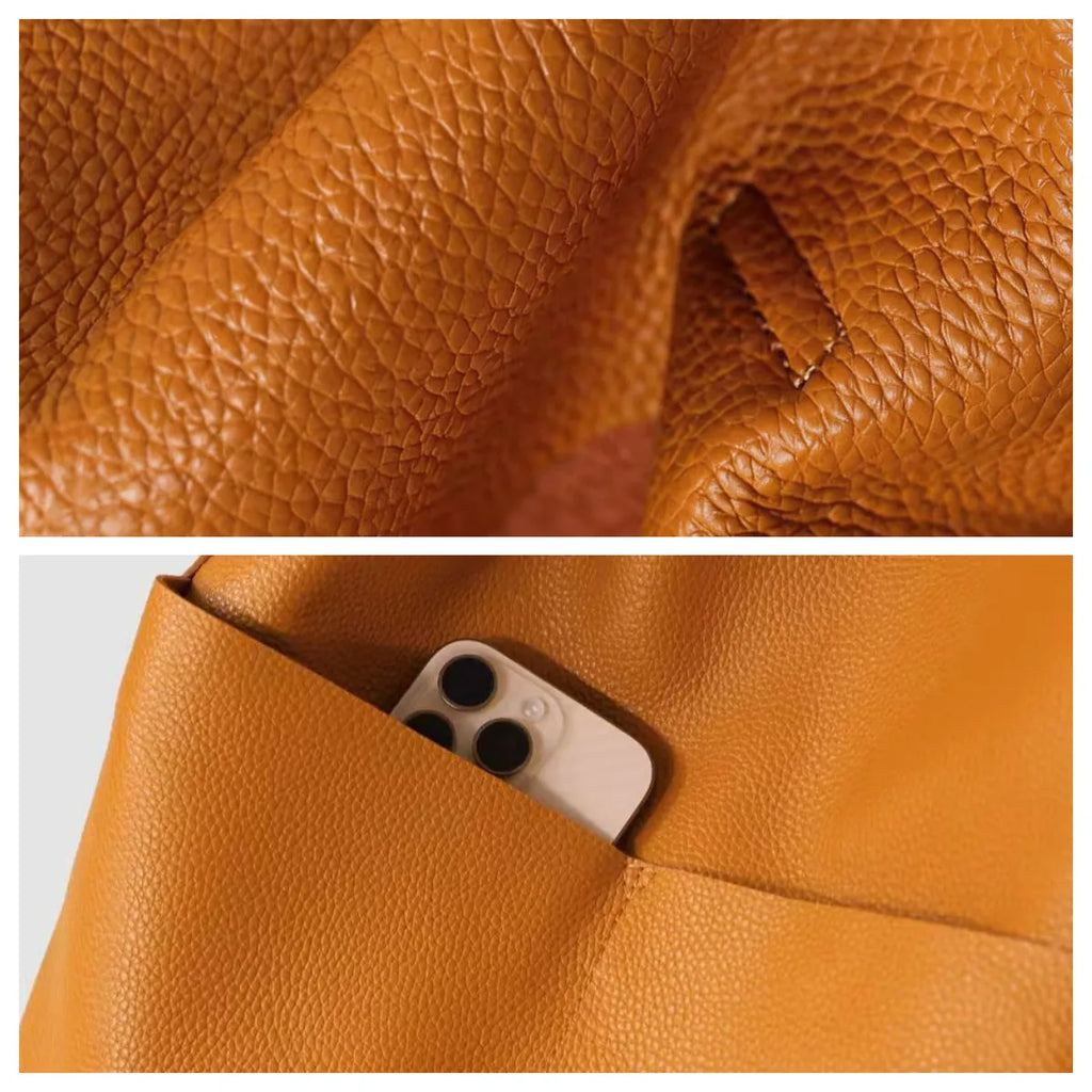 Close-up of brown leather texture with a phone pocket feature.