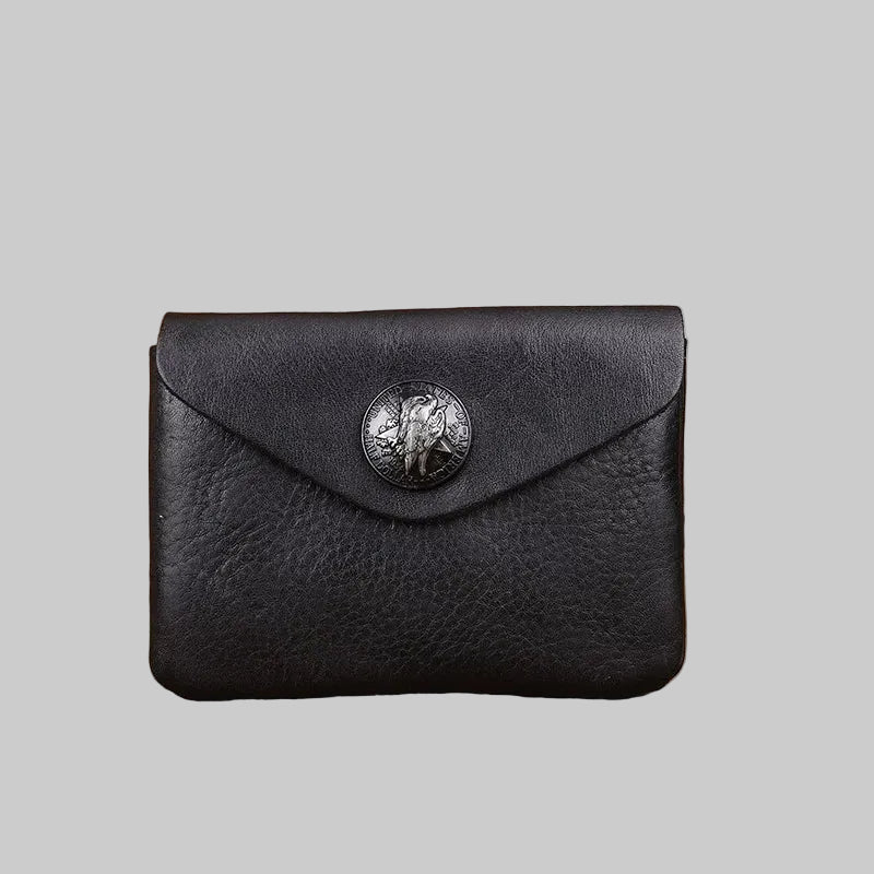 Black leather wallet with a metallic emblem on a wooden surface