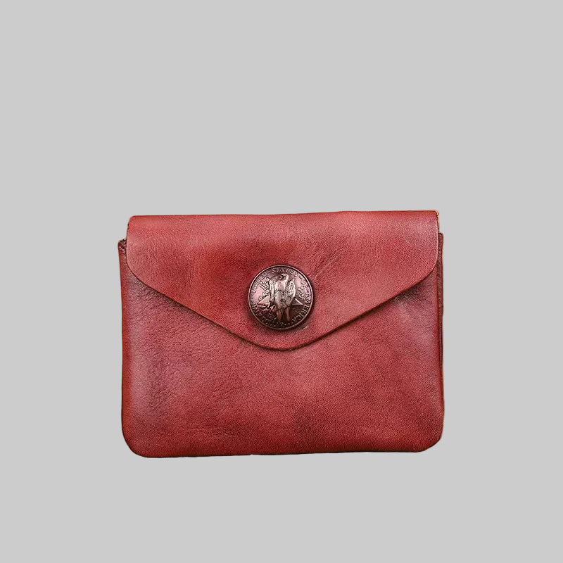 Red leather wallet with a decorative button on a wooden surface
