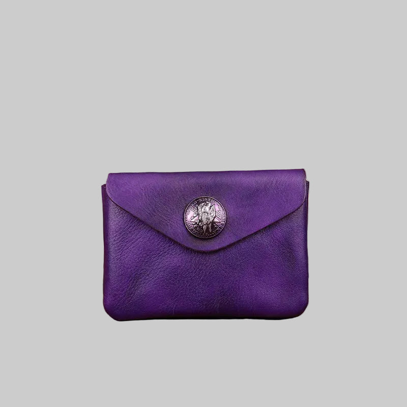Purple leather wallet with a decorative button on a wooden surface