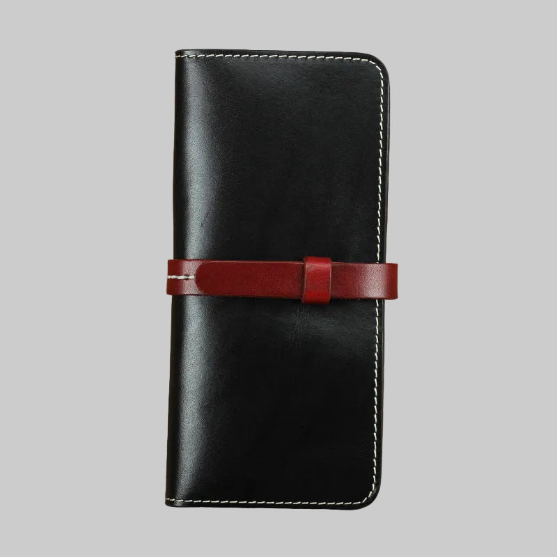 Black leather wallet with a red strap on a brown background