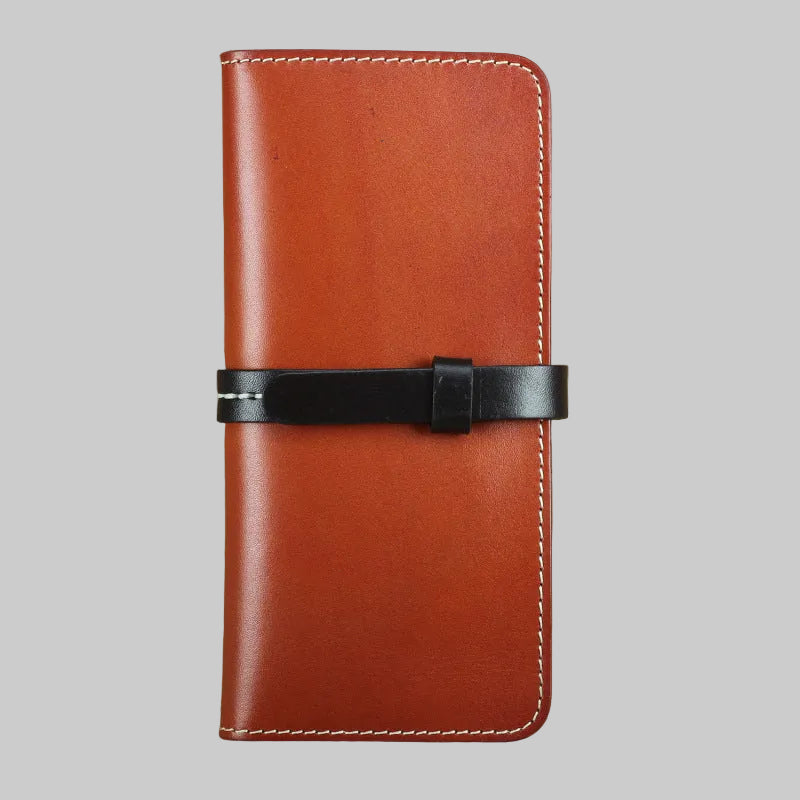 Brown leather wallet with a black strap on a textured brown background