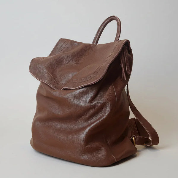 Brown leather backpack on a light gray background