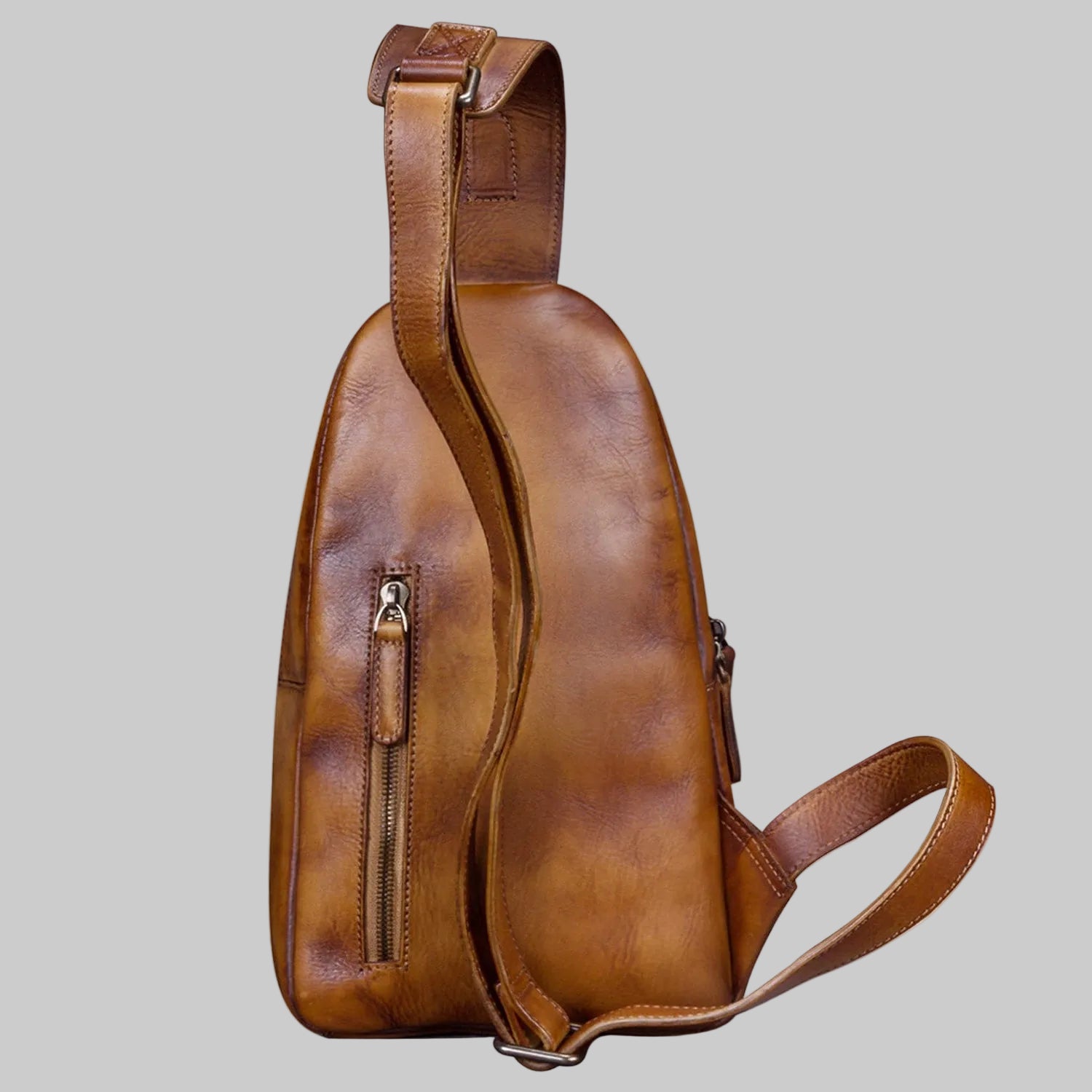 Brown leather sling bag on a white background